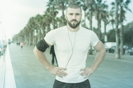 Athletic male stopped to rest while runningの写真素材