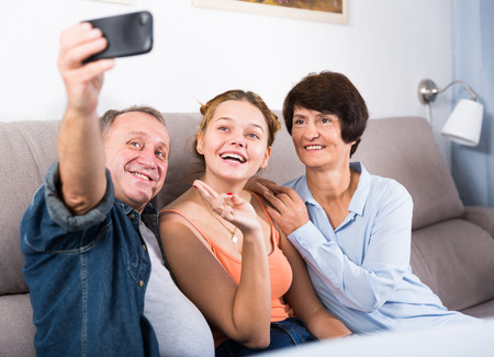 Happy family is taking selfie on the phone at home.の写真素材