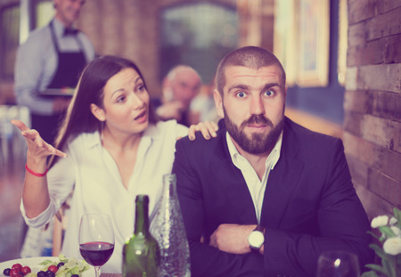 quarreled visitors upset female and male in restaurant on celebrateの写真素材