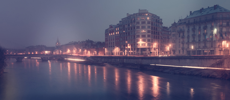 View on the night light of buildings near river in Grenoble of France outdoors.の写真素材