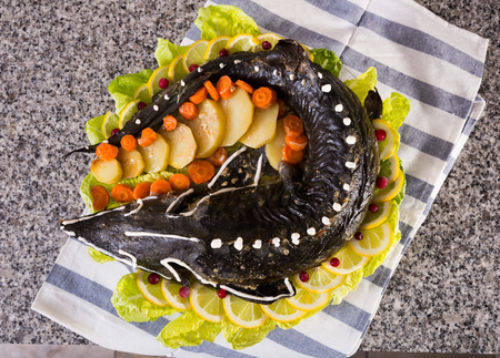 Dish of fried sturgeon with a vegetable servit at tableの写真素材