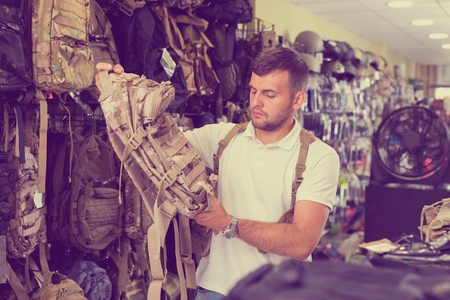 Adult male customer choise camouflage bag in airsoft shopの写真素材