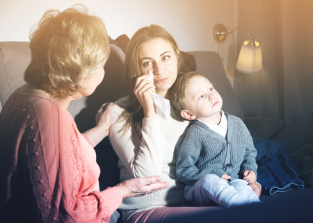 Aged woman is comforting emotional daughter after watching film at home.の写真素材