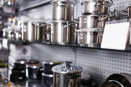 Illustration of nice  saucepan on the shelfs of the dishes department in the store