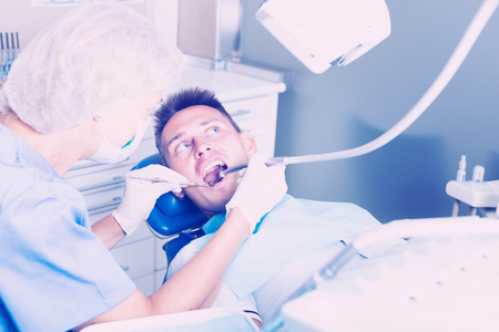 Young man visiting dentist, taking care of his health and dental hygieneの写真素材
