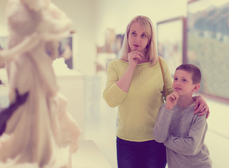 Attractive mother and son looking at classical statues in museumの写真素材