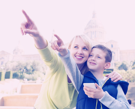 Smiling mother and son pointing at sight during sightseeing tourの写真素材