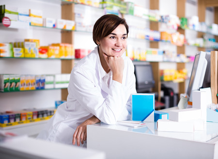 Smiling american female pharmacist demonstrating assortment of pharmacyの写真素材