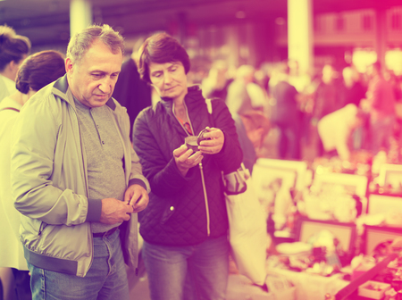 Portrait of mature family couple looking vintage goods at flea market の写真素材
