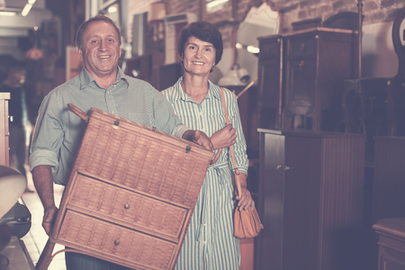 Adult couple is shopping the old nightstand in the antique storeの写真素材