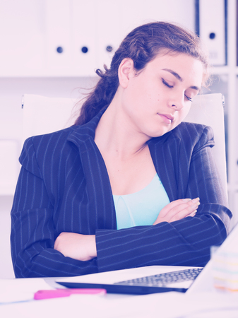 Woman beginner is sleeping in office after first day at work.の写真素材