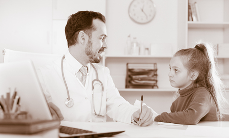 Teenage female visitor having consultation with male doctor in hospitalの写真素材