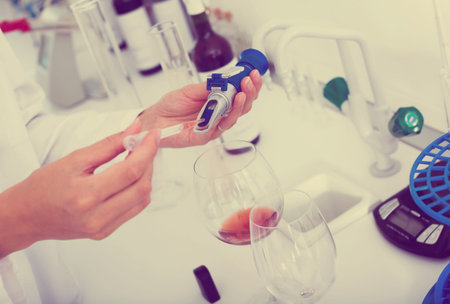 Close up on hands testing quality in chemical laboratory 