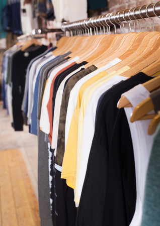 Colorful beauty dress hanging on wood hangers in the clothing storeの写真素材