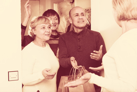 Mature friends are talking about their leisure at hallway.の写真素材