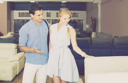 Man and woman are choosing of new sofa in furniture storeの写真素材