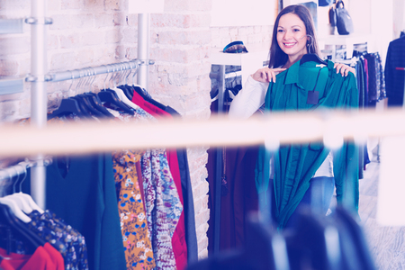 Portrait of adult woman customer choosing shirt  in the fashion storeの写真素材