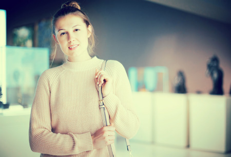Portrait of female visitor in historical museum looking at art exhibitionの写真素材