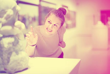 Happy cheerful positive  female visitor looking at exhibition in museum of ancient sculpture の写真素材