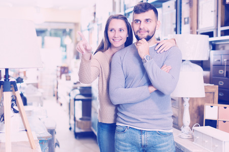 Young happy couple choosing vintage things for apartment in furnishings storeの写真素材