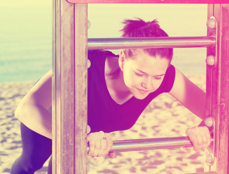 Girl is pushing up on the beach.
