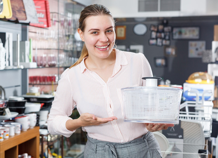 Smiling woman is choosing new herb spinner for her house in the shopの写真素材