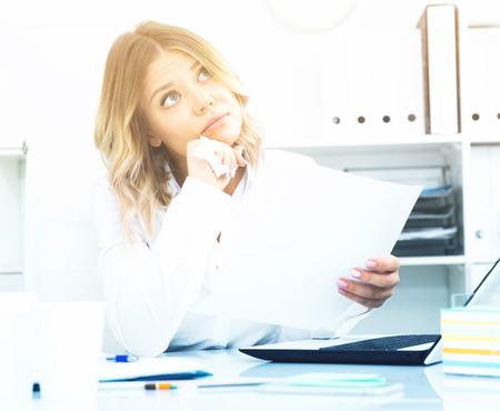 Pensive young girl in business clothes in modern officeの写真素材