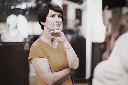 Portrait of calm senior woman visiting museum of ancient sculpture for the exhibitionの写真素材