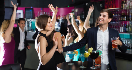 Cheerful positive glad colleagues dancing on corporate party with cocktails in hands
の写真素材