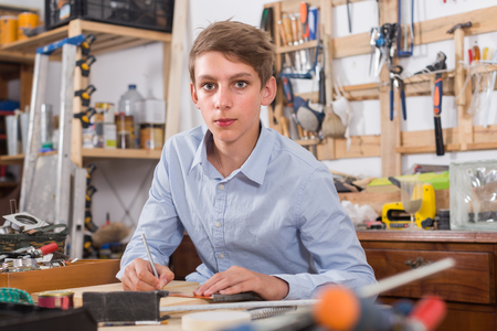 Handsome germany teenager  smiling and working with wood in the workshop
の写真素材