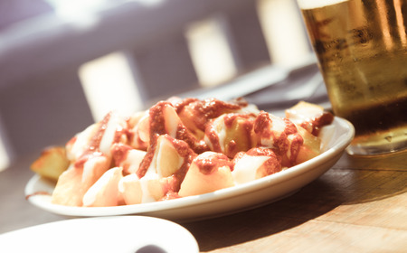 Patatas bravas spanish national dish standing with drink on the tableの写真素材