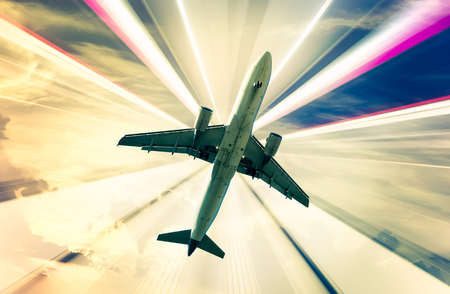 Airplane flying on bright divergent rays backgroundの写真素材