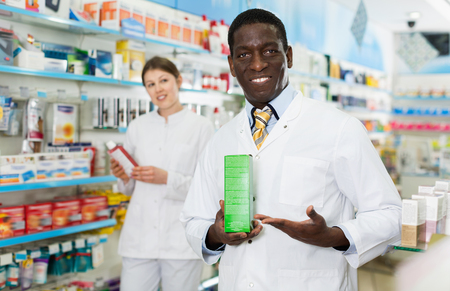 Portrait of experienced happy  smiling male pharmacist counseling about medicines in pharmacyの写真素材