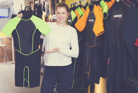 Sporty happy woman is satisfied of new costumes for diving in the store.の写真素材