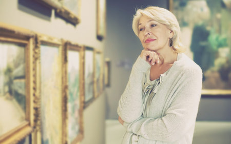 Portrait of senior female near picture collection in the museum