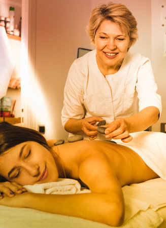Young female client enjoying relaxing massage in beauty salonの写真素材
