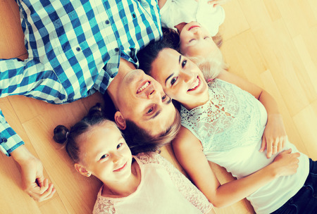 Family values: portrait of happy parents with little girls in apartmentの写真素材
