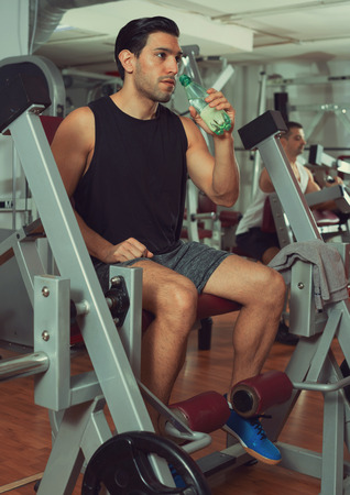 Portrait of strong sporty man resting during workout in gymの写真素材