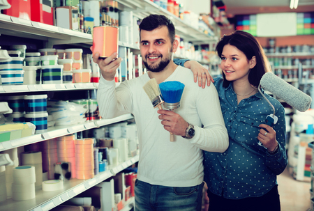 Woman and man are deciding on best paint in paint supplies store.の写真素材