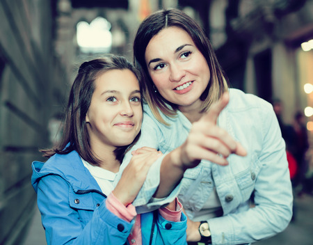 Young mother giving explanations to daughter during a sightseeing tour. Focus on both personsの写真素材