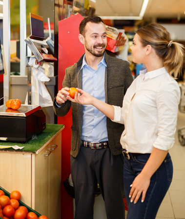 Smiling couple is weighing products in fruit department in the supermarketの写真素材