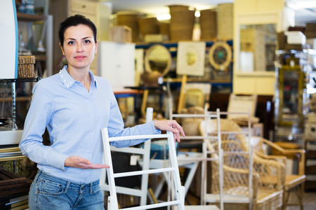 Female standing with stepladder in decoration and furniture storeの写真素材
