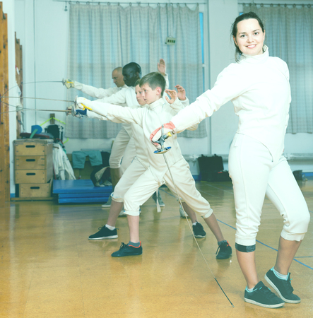 Portrait of smiling sporty young cheerful  glad woman with foil at fencing workoutの写真素材