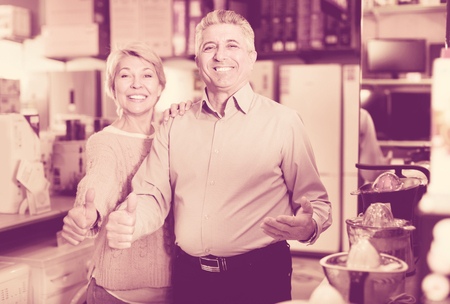 Cheerful husband and the wife are satisfied with wide range of household appliances in shopの写真素材