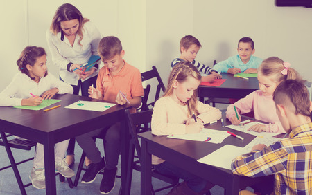 Group of children in elementary age drawing together at classroomの写真素材