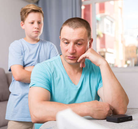 Man is offended and son is not wanting talking with him at the home.の写真素材