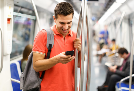 Man is looking on phone in the train in the underground.の写真素材