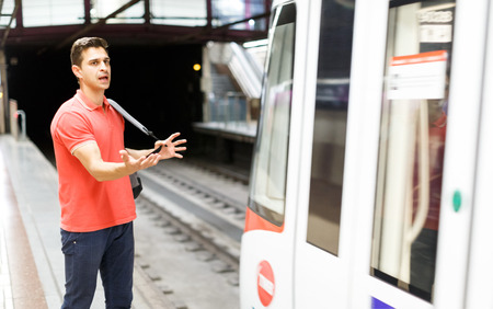 Man is standing on platform and waiting train that left in the underground.の写真素材