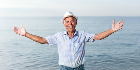 Happy satisfied mature man posing near ocean aloneの写真素材