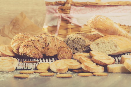 Various bakery and pastry products on rattan mat on wooden tableの写真素材